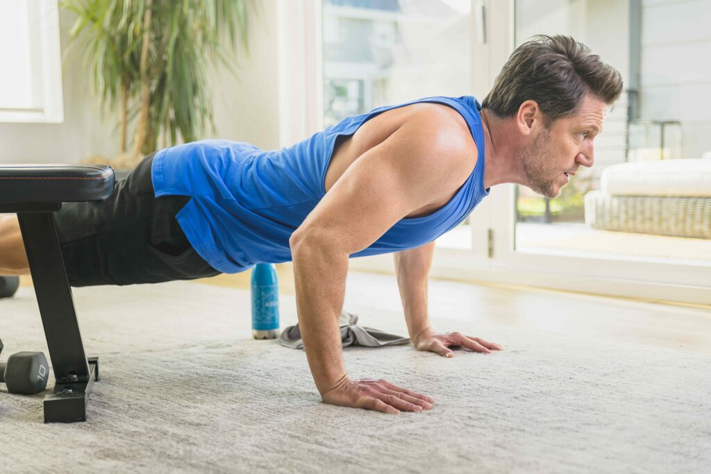 A middle-aged man exercising indoors, highlighting how an active lifestyle supports confidence and overall skin health as men age.