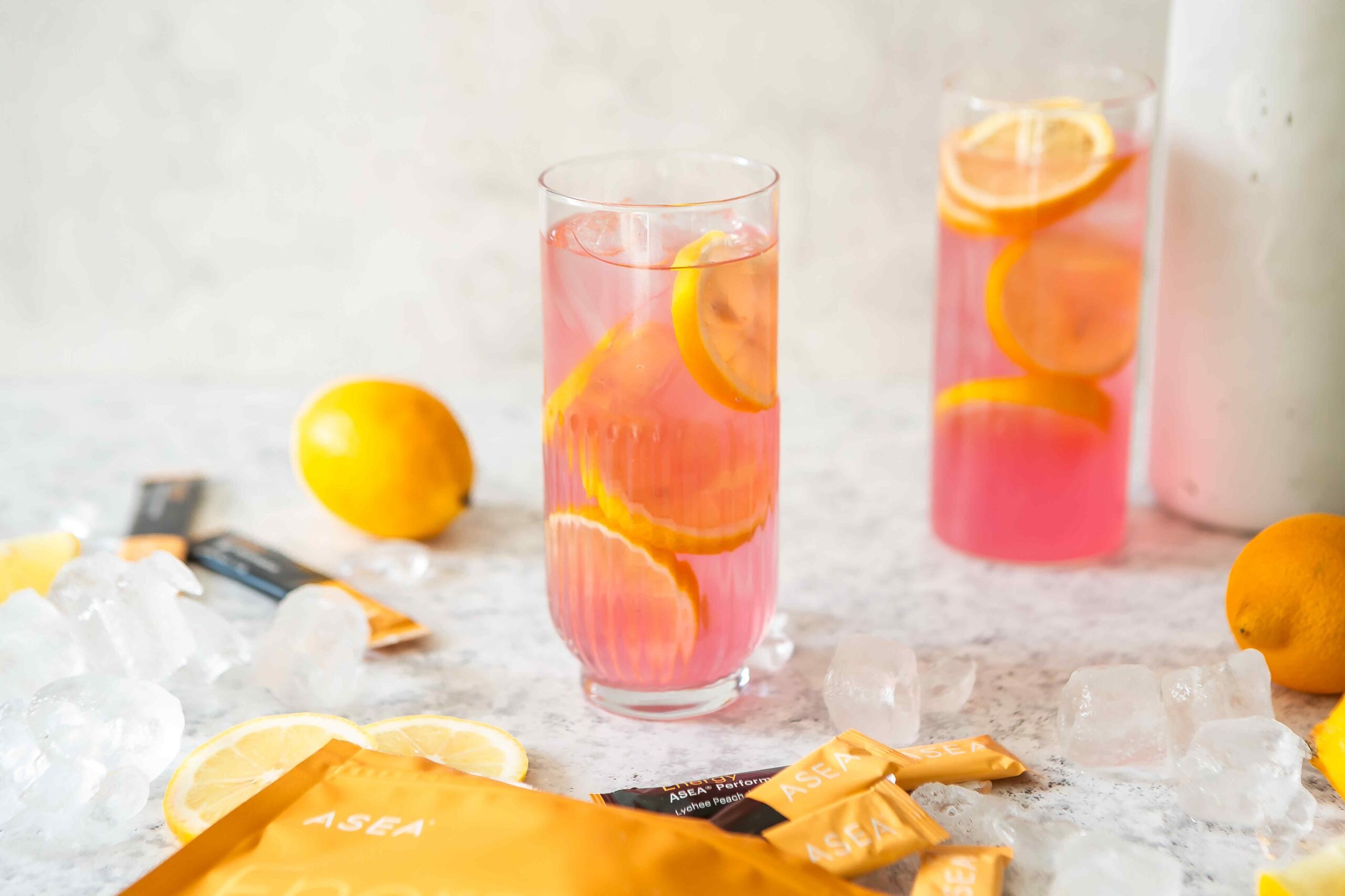 Fresh lemon juice, ice, and ASEA Energy stick packs arranged on a countertop, highlighting the simple ingredients used in this energized lemonade recipe.