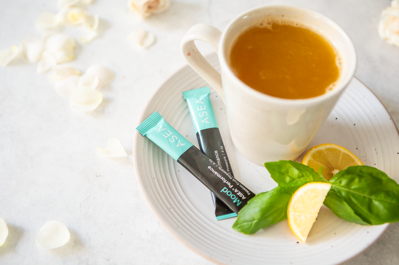 A softly styled cup of ASEA Mood tea surrounded by fresh herbs and citrus reflects a peaceful evening ritual designed to help unwind and support a calm mindset.