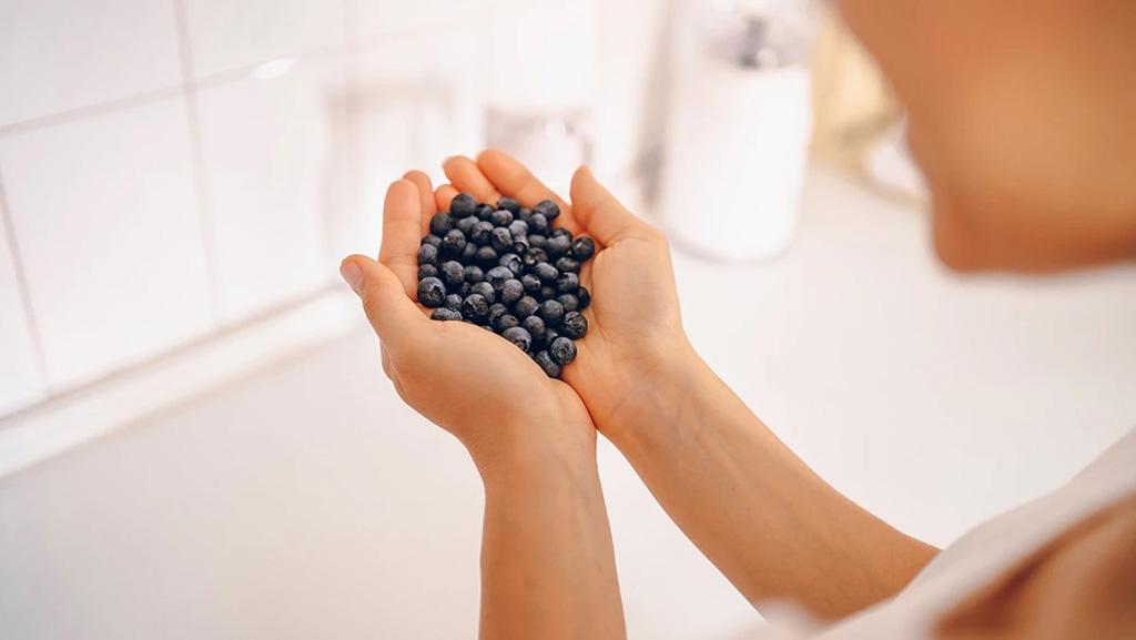 Hände halten eine Portion dunkler Beeren als Beispiel für pflanzliche Inhaltsstoffe in einer Rezeptur