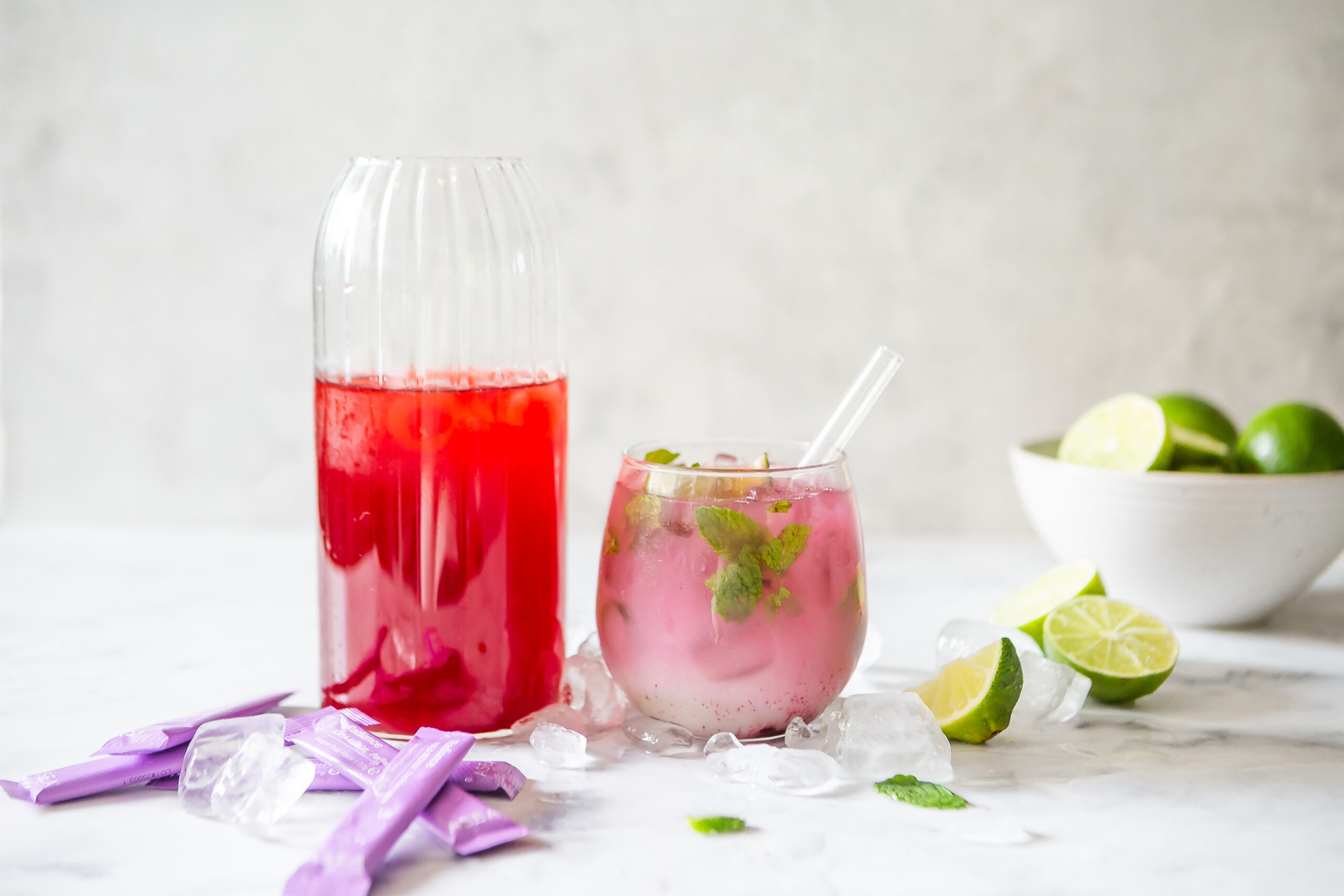Radiance Mint Lime Cooler featuring fresh lime wedges, mint leaves, ice, and ASEA Radiance in a refreshing pink wellness beverage.